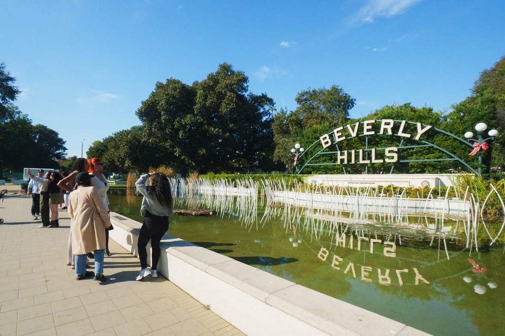 Private Beverly Hills tour guests near Beverly Hills sign and fountain